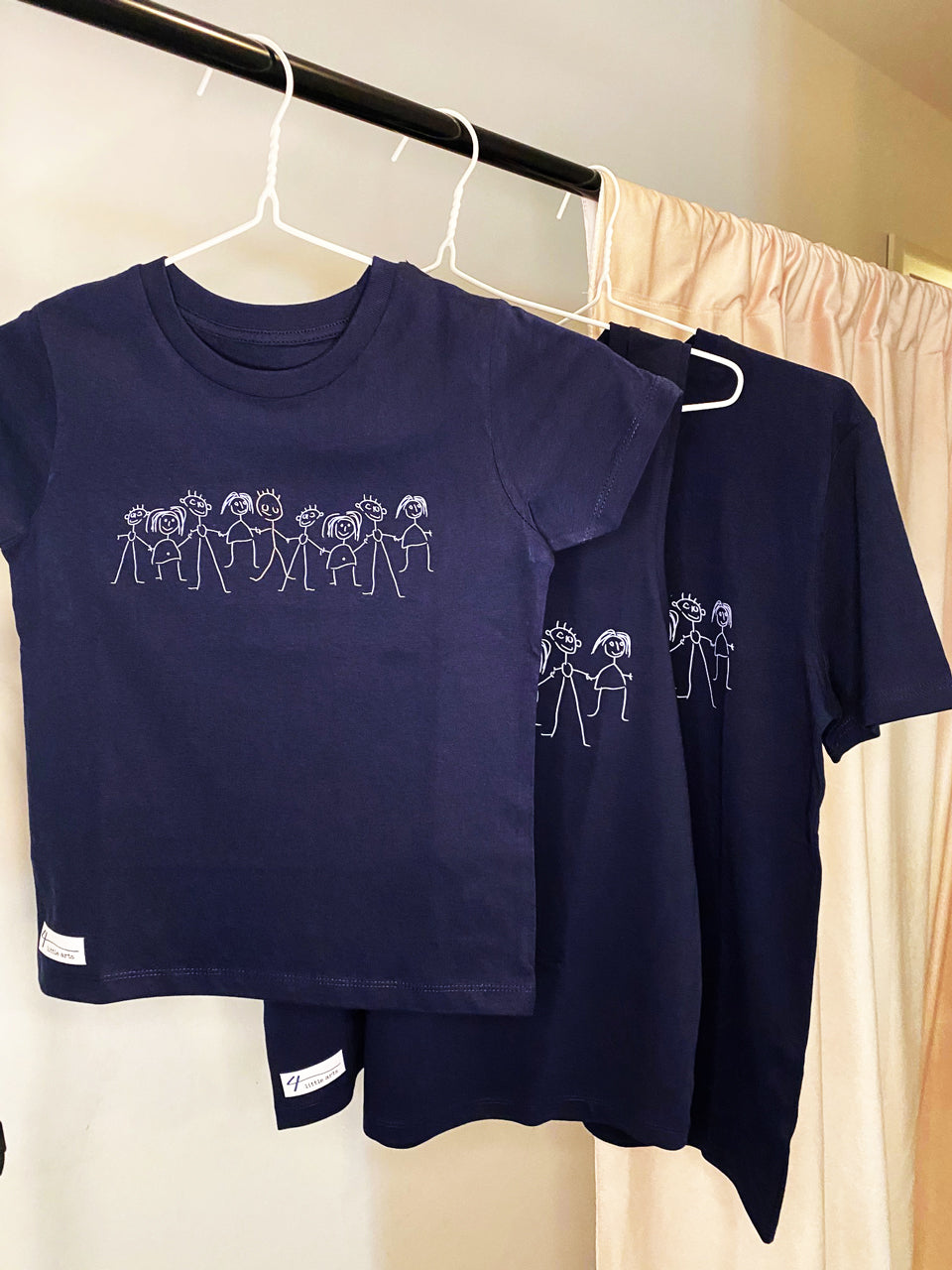 Dunkelblaue Shirts mit dem Aufdruck 'Inklusion' für Erwachsene und Kinder aus Bio-Baumwolle.